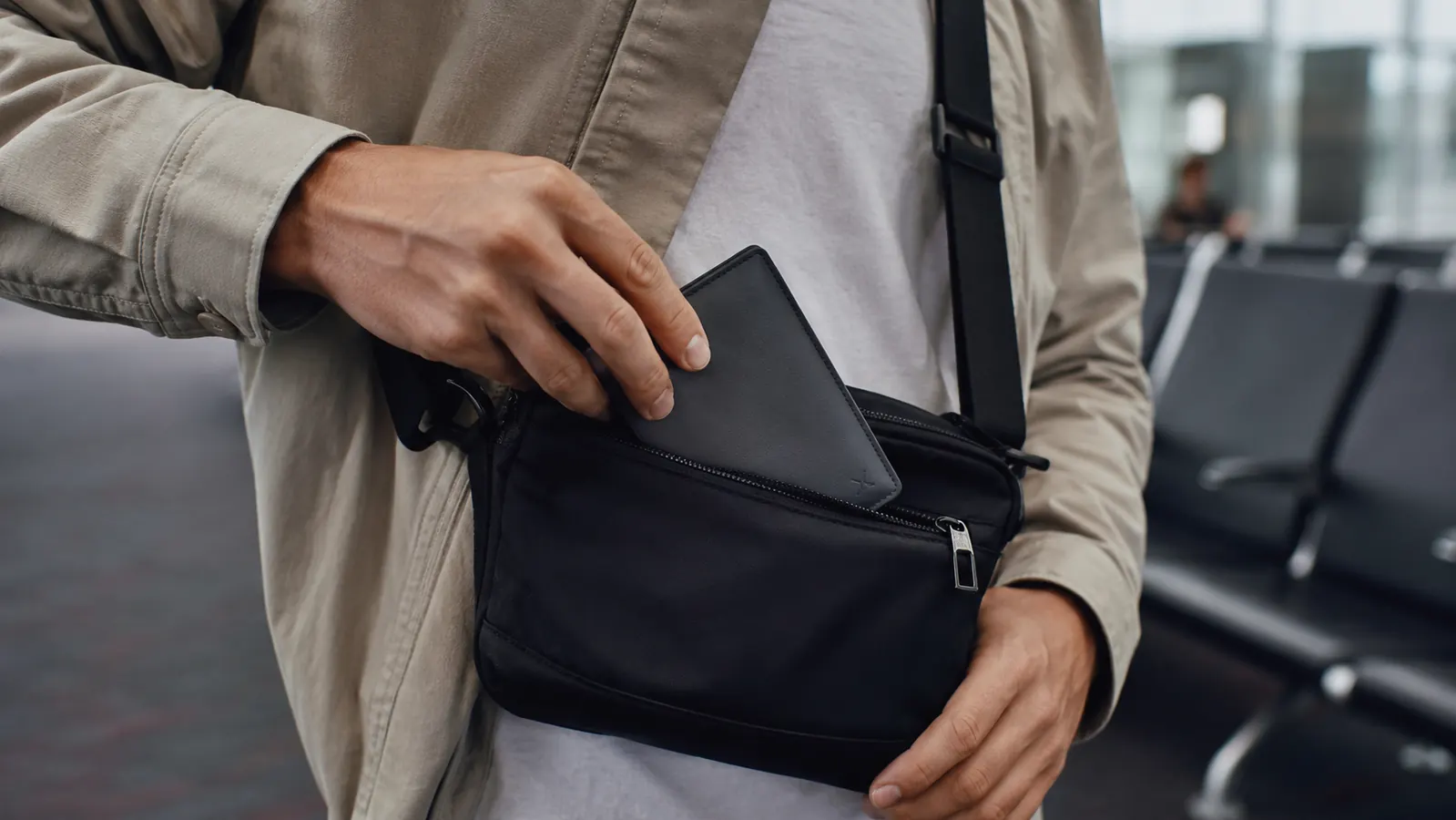 Travel wallet tucked inside a crossbody bag at airport security